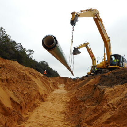 Setting piping in excavation to fit up in trench